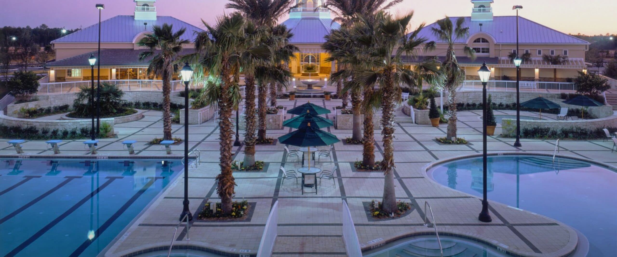 A swimming pool and palm trees at dusk at Bartram Springs