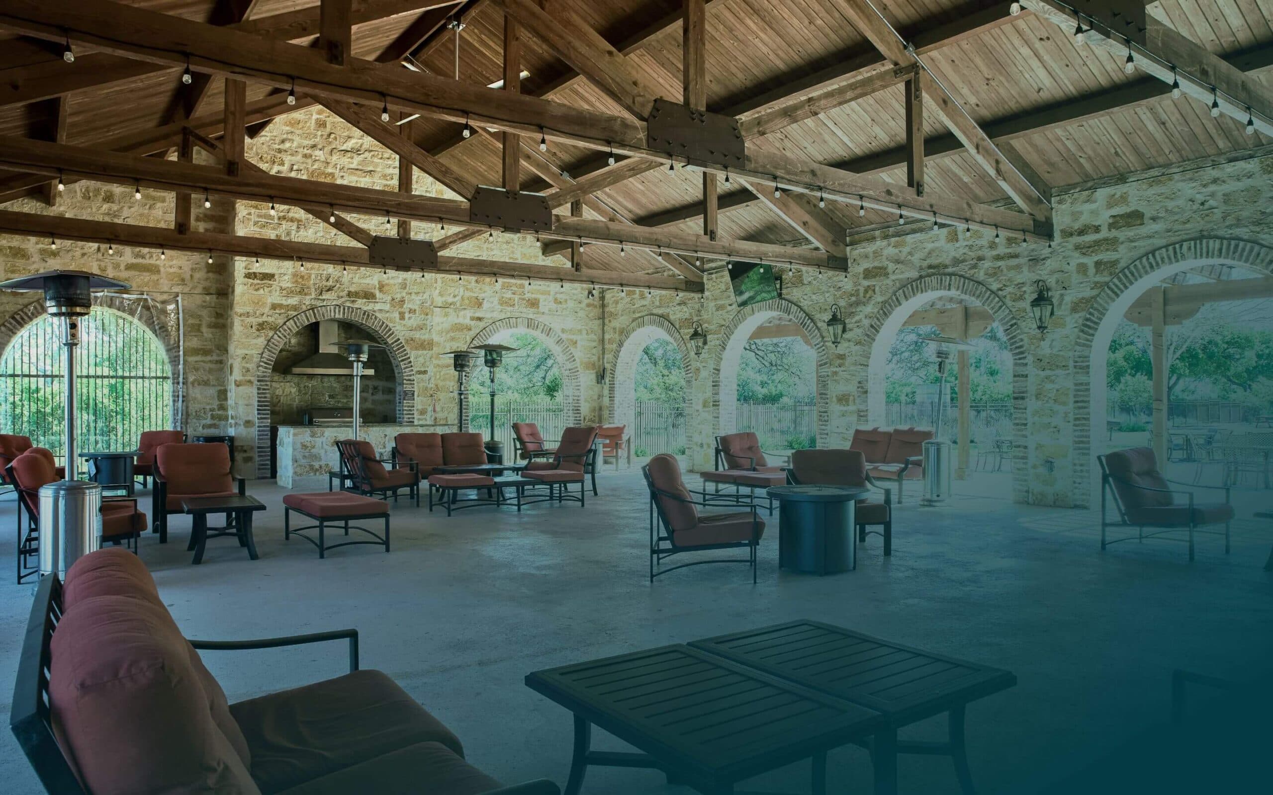 A stone covered patio with chairs and tables.