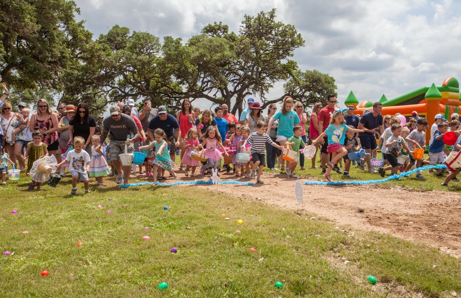 A group of people standing on a grassy field.