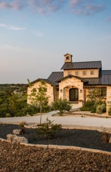A home with a stone driveway and landscaping.